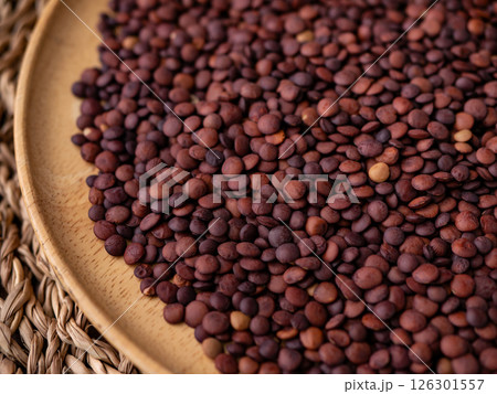 Organic uncooked seeds dark red brown lentils. 126301557