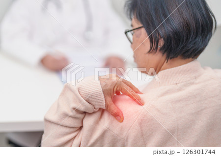 Elderly Woman having Shoulder and Neck and consulting doctor in hospital. Muscle painful due to Myofascial pain syndrome and Fibromyalgia, rheumatism, Scapular pain, Cervical Spine. ergonomic concept Elderly Woman having Shoulder and Neck and consulting doctor in hospital. Muscle painful due to Myofascial pain syndrome and Fibromyalgia, rheumatism, Scapular pain, Cervical Spine. ergonomic concept 126301744