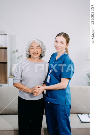 Young Caregiver doctor examine older patient use blood pressure gauge. woman therapist nurse at nursing home taking care of senior elderly woman sit on sofa. Young Caregiver doctor examine older patient use blood pressure gauge. woman therapist nurse at nursing home taking care of senior elderly woman sit on sofa. 126302357