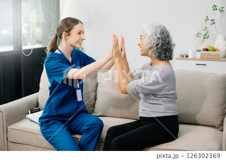 Doctors explain the use of medication to patients. Medical doctor holing senior patient's hands and comforting her on sofa Doctors explain the use of medication to patients. Medical doctor holing senior patient's hands and comforting her on sofa 126302369