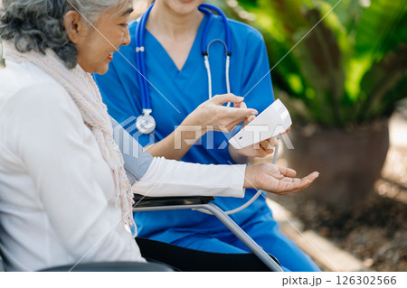 Elderly asian senior woman on wheelchair with Asian careful caregiver and encourage patient, walking in garden. with care from a caregiver 126302566