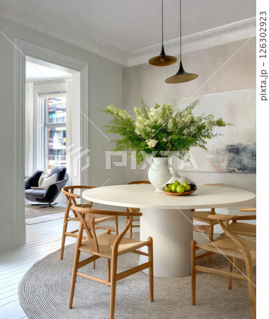 Elegant dining area with natural decor and modern furnishings in bright light Elegant dining area with natural decor and modern furnishings in bright light 126302923