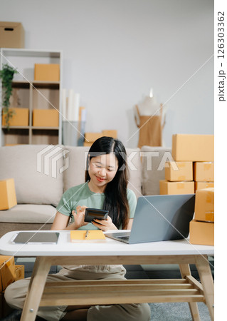 Startup small business SME, Entrepreneur owner woman using smartphone or tablet taking receive and checking online purchase shopping orde 126303362