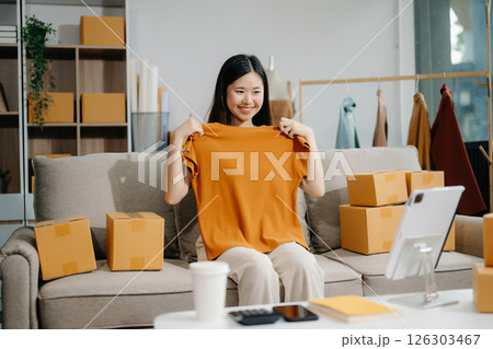 Asian lady blogger showing clothes in front of the camera to recording vlog video live streaming 126303467