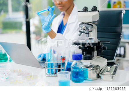 female scientist working with micro pipettes analyzing biochemical samples, advanced science chemical laboratory 126303485