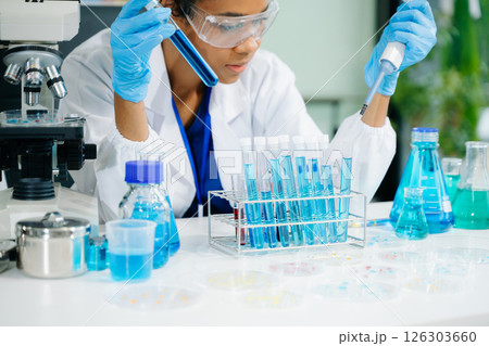 female scientist working with micro pipettes analyzing biochemical samples, advanced science chemical laboratory 126303660