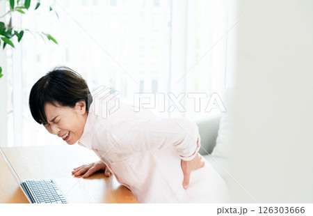 リビングで腰痛に苦しむ中高年女性 126303666
