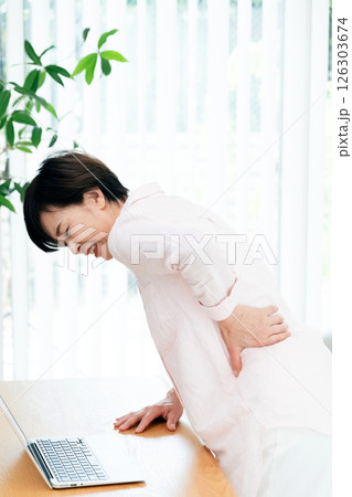 リビングで腰痛に苦しむ中高年女性 126303674