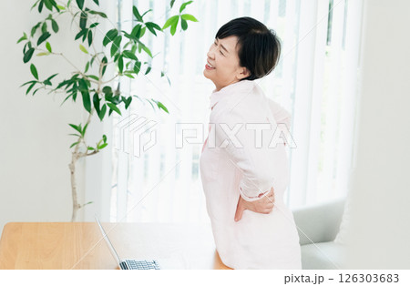 リビングで腰痛に苦しむ中高年女性 126303683