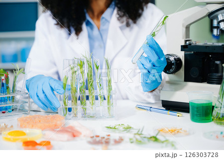 Food scientist in a lab testing food samples with modern equipment, ensuring food safety and quality control. Food scientist in a lab testing food samples with modern equipment, ensuring food safety and quality control. 126303728