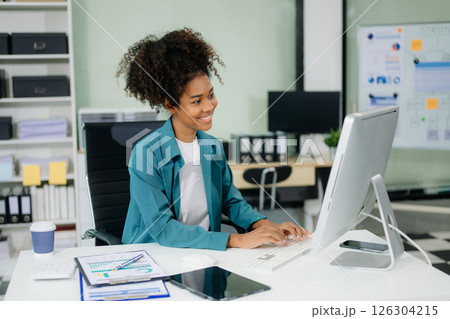 Young beautiful woman using laptop and tablet while sitting at her working place. 126304215