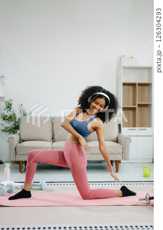 A young woman practices yoga and stretching with a mat and gym props, showcasing wellness, motivation, A young woman practices yoga and stretching with a mat and gym props, showcasing wellness, motivation, 126304293