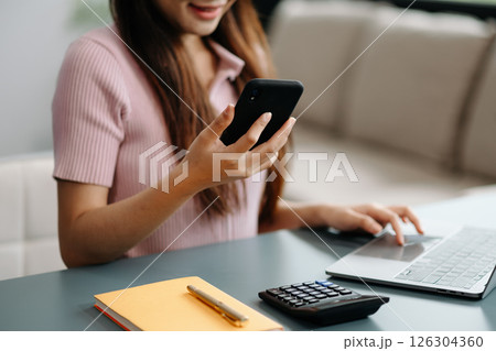 Confident businesswoman working on laptop,tablet and smartphone at her workplace at office. Confident businesswoman working on laptop,tablet and smartphone at her workplace at office. 126304360