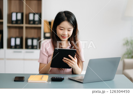 Asian woman sitting at a desk using a laptop computer Navigating Finance and Marketing with Technology Asian woman sitting at a desk using a laptop computer Navigating Finance and Marketing with Technology 126304450