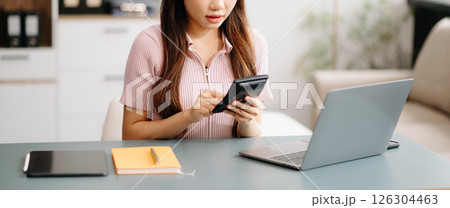 Asian woman sitting at a desk using a laptop computer Navigating Finance and Marketing with Technology Asian woman sitting at a desk using a laptop computer Navigating Finance and Marketing with Technology 126304463