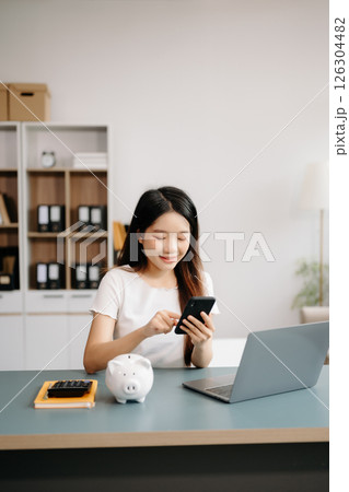 Women are putting coins in a piggy bank for a business that grows for profit and saving money for the future. Women are putting coins in a piggy bank for a business that grows for profit and saving money for the future. 126304482