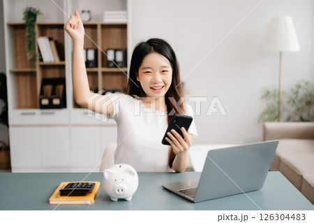 Women are putting coins in a piggy bank for a business that grows for profit and saving money for the future. Women are putting coins in a piggy bank for a business that grows for profit and saving money for the future. 126304483