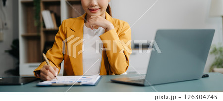 Confident businessman working on laptop,tablet and smartphone at her workplace at office. 126304745