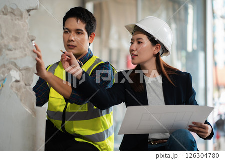civil engineer and worker discussing issues at the construction site. 126304780