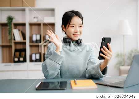 Asian woman using the smartphone and tablet on the sofa at home office Asian woman using the smartphone and tablet on the sofa at home office 126304948