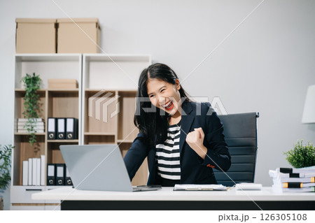 Asian business woman are delighted and happy with the work they do on their tablet, laptop Asian business woman are delighted and happy with the work they do on their tablet, laptop 126305108