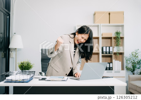 Asian business woman are delighted and happy with the work they do on their tablet, laptop 126305212