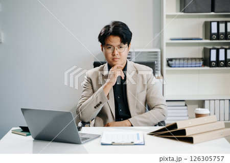 Young business man working at office with laptop, tablet and taking notes on the paper. 126305757