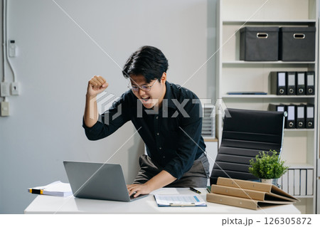 Young business man working at office with laptop, tablet and taking notes on the paper. Young business man working at office with laptop, tablet and taking notes on the paper. 126305872