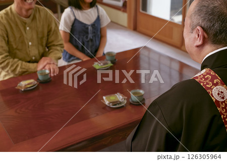 お寺の住職とお話をしている檀家 126305964