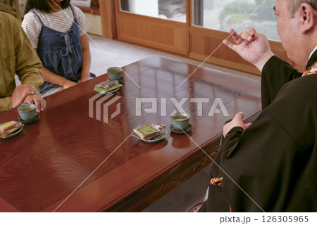お寺の住職とお話をしている檀家 126305965