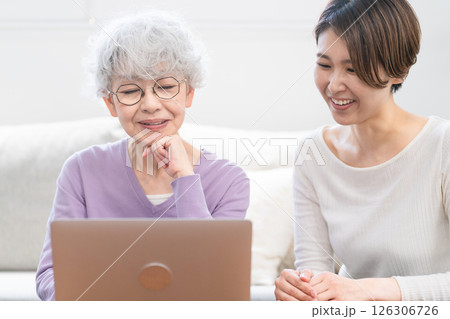 若い女性にパソコン操作を習うシニア女性 若い女性にパソコン操作を習うシニア女性 126306726