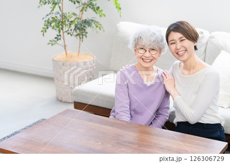 並んで座る若い女性とシニア女性 並んで座る若い女性とシニア女性 126306729