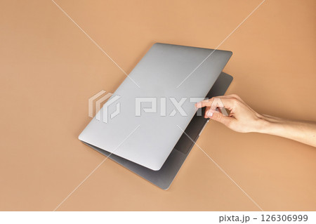 female hand open or close laptop on beige table, top view female hand open or close laptop on beige table, top view 126306999