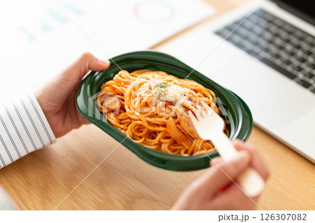 会社のデスクでナポリタンパスタを食べるミドル女性 126307082