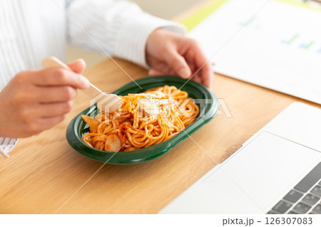 会社のデスクでナポリタンパスタを食べるミドル女性 会社のデスクでナポリタンパスタを食べるミドル女性 126307083