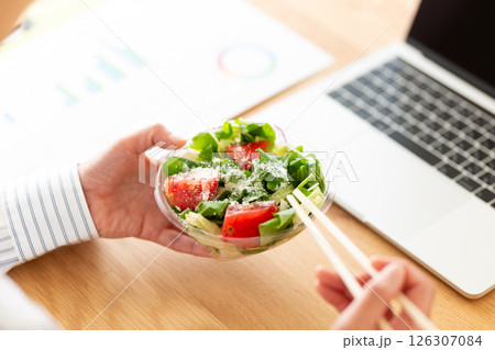 会社のデスクで生野菜サラダを食べるミドル女性 126307084