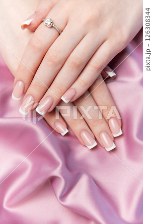 Woman showing french manicure on pink satin background 126308344