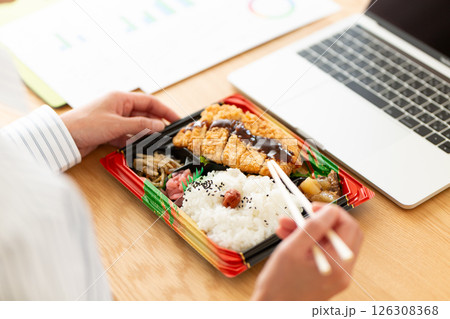会社のデスクでトンカツ弁当を食べるミドル女性 会社のデスクでトンカツ弁当を食べるミドル女性 126308368