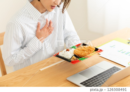 会社のデスクで食欲不振に苦しむミドル女性 会社のデスクで食欲不振に苦しむミドル女性 126308491