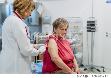 Elderly patient being vaccinated by doctor. Elderly patient being vaccinated by doctor. 126308712