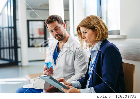 Female medical sales representative presenting medication to doctor 126308733