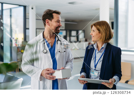 Female medical sales representative presenting medication to doctor 126308734