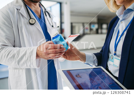 Female medical sales representative introducing pharmaceutical products to doctor. Female medical sales representative introducing pharmaceutical products to doctor. 126308741