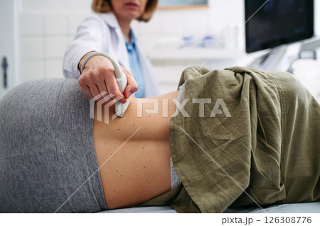 Medical examination with ultrasound probe on lower back Medical examination with ultrasound probe on lower back 126308776