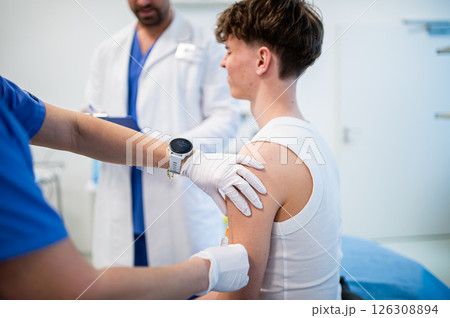 Vaccination of teenage boy during routine health checkup at hospital 126308894