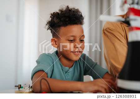 Father and son exploring STEM, robotics, and technology together. 126308931