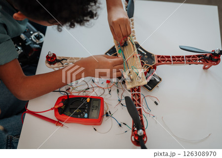 Young schoolboy assembling robotic kit, working with circuit board at home. Young schoolboy assembling robotic kit, working with circuit board at home. 126308970