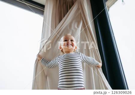 Adorable toddler boy playing hide and seek at home. Adorable toddler boy playing hide and seek at home. 126309026
