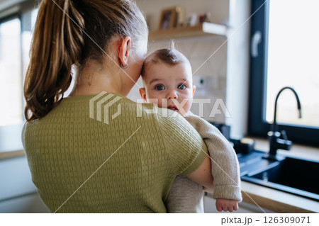 Big sister holding small little brother in her arms, taking care. 126309071
