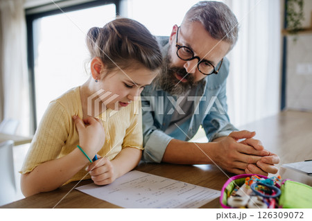 Father helping his daughter with homework. 126309072